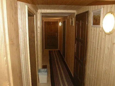 Dřevem obložená chodba v podkroví s dveřmi do pokojů