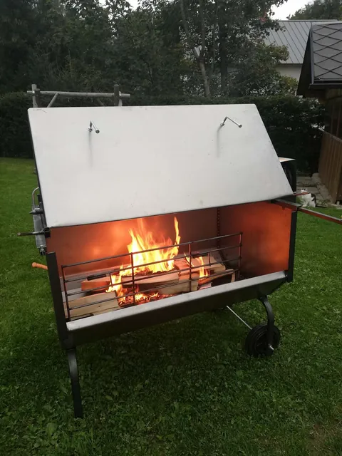 Rozpálený gril s rožněm na zahradě