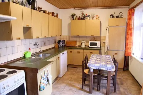 Kuchyňská linka se sporákem, mikrovlnnou troubou, lednicí a jídelním stolem
