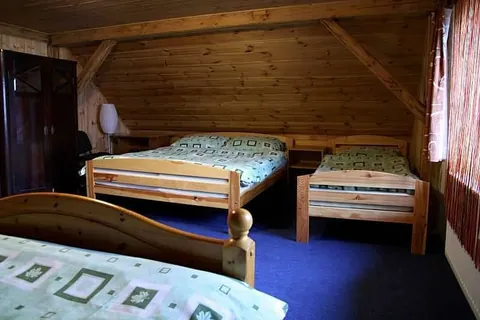 Podkrovní pokoj s dřevěným stropem, manželskou postelí a dalšími lůžky